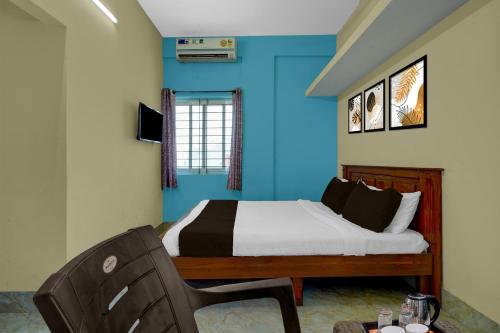 a bedroom with blue walls and a bed and a chair at Hotel O Abbigere Lakeview Bangalore Formerly Shree Venkateshwar Atithi Comforts in Chik Bānavar