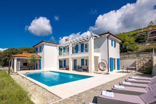 a villa with a swimming pool and chairs at Villa Luka with Private Pool & Sea View in Labin