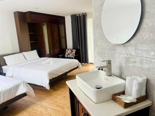 a bathroom with a sink and a bed and a mirror at MoChy Homestay in Thôn Trường Giang