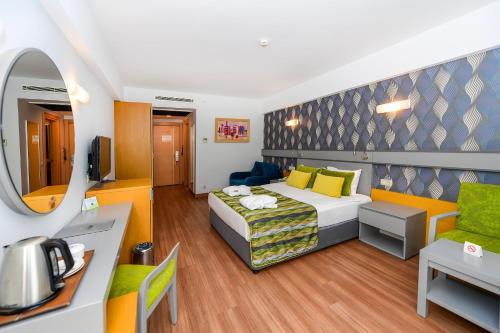 a hotel room with a bed and a couch and a table at Sunis Kumköy Beach Resort Hotel & Spa in Side
