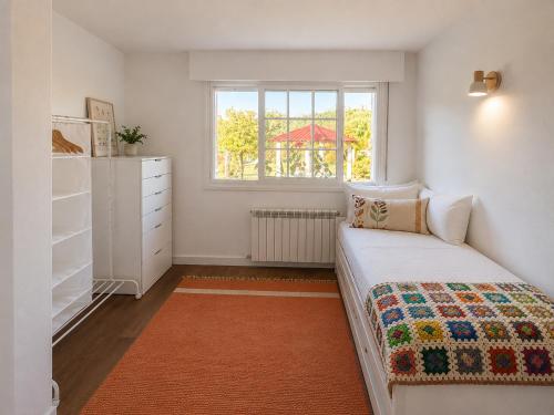 a small bedroom with a bed and a window at Holibai Nova Anduriña, Casa rustica con jardín, Gondomar in Gondomar