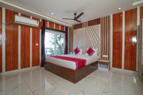 a bedroom with a bed and a large window at TN RESORTS in Mandarmoni