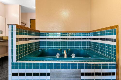 ein Badezimmer mit Badewanne und blau-weißen Fliesen in der Unterkunft Super 8 by Wyndham Bourbonnais/Kankakee Area in Bourbonnais