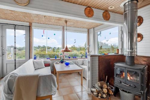 a living room with a fireplace and a stove at Cottage With A View in Roslev