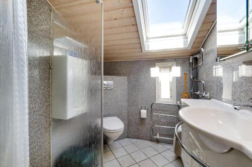 a bathroom with a toilet and a sink and a window at Cottage With A View in Roslev