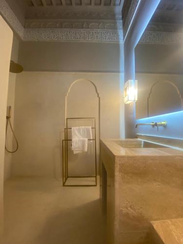 a bathroom with a sink and a towel rack at Riad Djannaat Exceptional private riad pool staff in Marrakesh