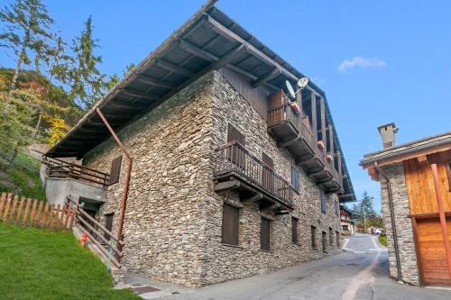 a stone building with a balcony on the side of it at Champlas Suite - Happy Rentals in Sestriere