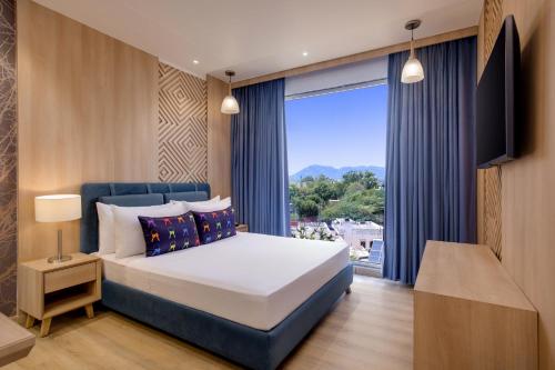 a bedroom with a bed and a large window at Keys Lite by Lemon Tree Hotels, Ajmer in Ajmer