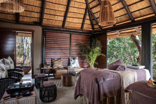 a room with a bed and chairs and windows at Ndlovu Safari Lodge in Vaalwater