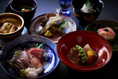 a table with plates of food on a table at Kocho in Kaga