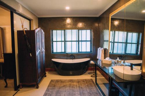 a large bathroom with a tub and a sink at The Bohemian Boutique Guesthouse in Tzaneen