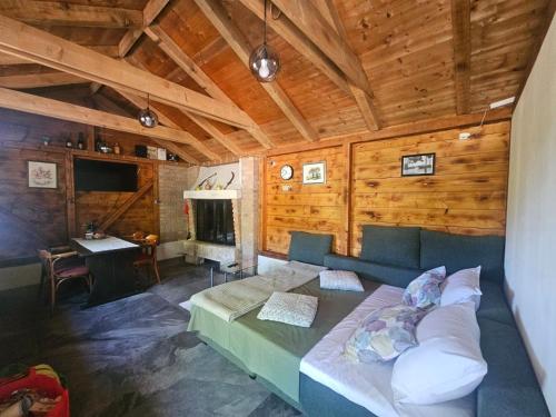 a living room with a bed in a room with wooden walls at Country House Speedy in Komiža