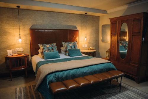 a bedroom with a large bed and a mirror at The Bohemian Boutique Guesthouse in Tzaneen