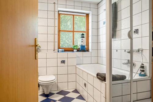 a bathroom with a tub and a toilet and a window at Fewo Stembers in Heideck
