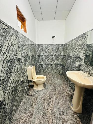a bathroom with a toilet and a sink at G Lake Guest House in Mahiyangana