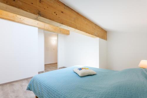 a bedroom with a blue bed and two windows at Le gecko avec jacuzzi in Saint-Germain