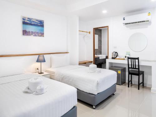 a hotel room with two beds and a bathroom at Grand Sattahip Hotel in Sattahip