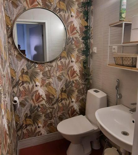 a bathroom with a toilet and a sink and a mirror at Hostelli Marja in Mikkeli