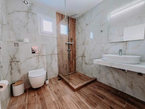 a bathroom with a shower and a toilet and a sink at Meraki Nikiti in Nikiti
