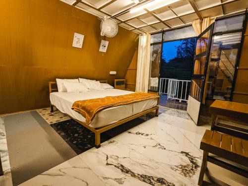 a bedroom with a bed and a large window at Vagamon leafmist frame cabin in Vagamon