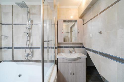 a bathroom with a shower and a sink and a tub at Althea in Skala Potamias