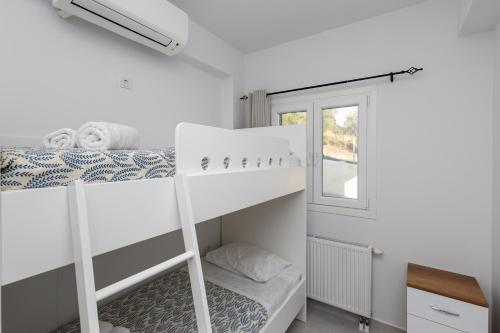 a bedroom with two bunk beds and a window at Villa Andrionas Private Pool & Total Privacy in Corfu