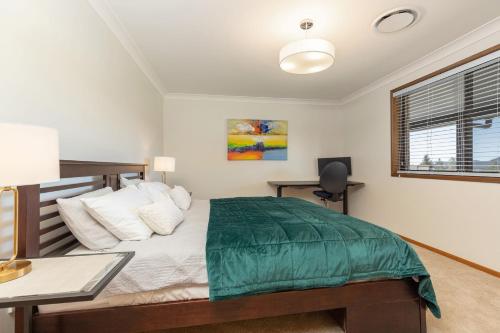a bedroom with a bed and a desk and a window at Byadbo in Tuncurry