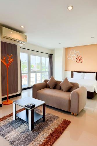 a living room with a couch and a bed at Phavina Hotel & Grand Boutique Rayong in Rayong