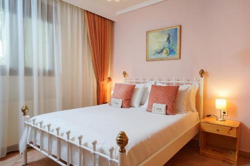 a bedroom with a white bed and a window at Althea in Skala Potamias