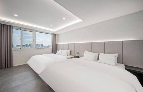 a hotel room with two beds and a window at Ehan Hotel in Mokpo
