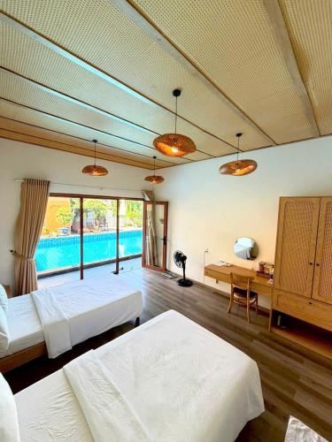 a large bedroom with two beds and a desk at PUN Retreat in Quy Nhon