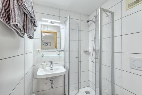 a white bathroom with a sink and a shower at Gasthof Rhönlust in Bischofsheim an der Rhön