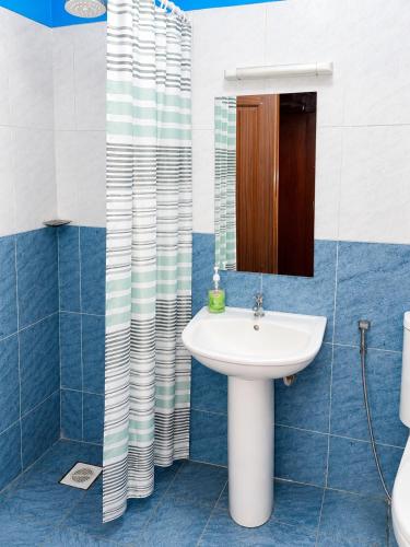 a bathroom with a sink and a mirror at Milimani Executive Suites Pool, GYM, Secure Parking Near Golf Club in Nakuru