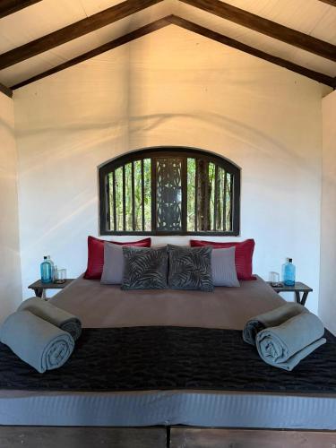 a large bed in a room with a window at The Trogon Knuckles in Rangala