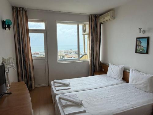 a bedroom with a bed and a large window at Хотел Черно море in Sveti Vlas