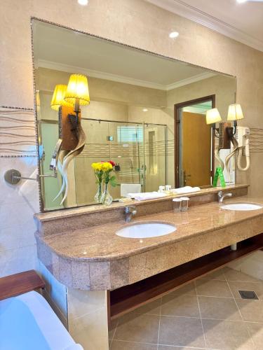 a bathroom with two sinks and a large mirror at Sawela Lodges in Naivasha