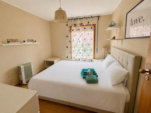 a bedroom with a large white bed and a window at Porto Nest in Senhora da Hora