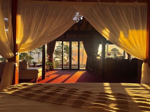 a bedroom with a bed with curtains and a couch at The Joglo Sekar Munduk in Pabean Buleleng