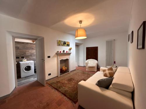 a living room with a white couch and a fireplace at Casa Spaziosa Vista Castello - 3minuti dal Centro di Barolo in Barolo