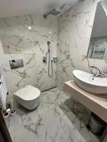 ein weißes Badezimmer mit Toilette und Waschbecken in der Unterkunft Hotel Ponti in Widin