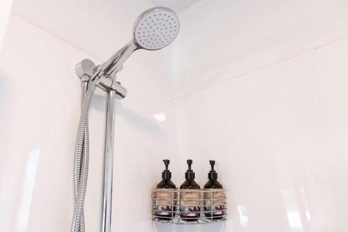 a shower with bottles of alcohol on a shelf at #2 Glenorchy Alpine Suite in Glenorchy