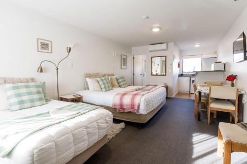 a bedroom with two beds and a table and a kitchen at #2 Glenorchy Alpine Suite in Glenorchy