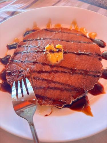 a plate with a steak with a fork on it at Beachaus Resort in Pandan