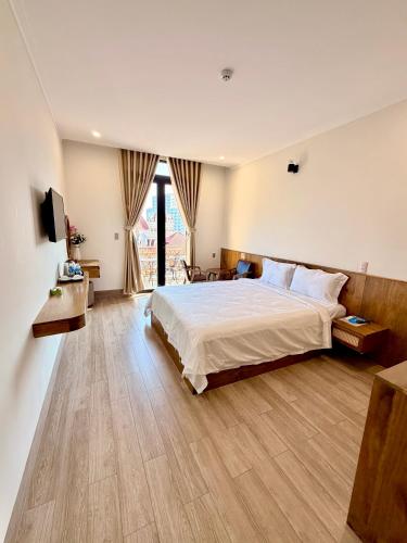 a bedroom with a large bed and a large window at Hùng Anh Hotel in Phan Thiet