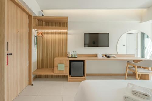 ein Zimmer mit einem Bett und einem Schreibtisch mit Fernseher in der Unterkunft Jace Ratchada Hotel in Bangkok