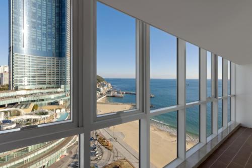 a room with windows looking out at the ocean at Pale De Cz Condo in Busan