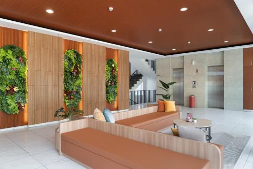a lobby with a couch and plants on the wall at Cove Limora in Bandung