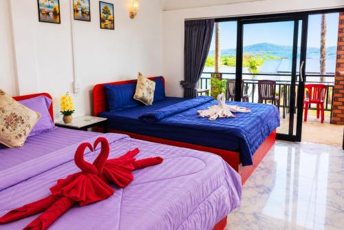 a bedroom with two beds with red ribbons on them at Antalya Hostel Bar & Restaurant in Kaôh Rŭng (3)