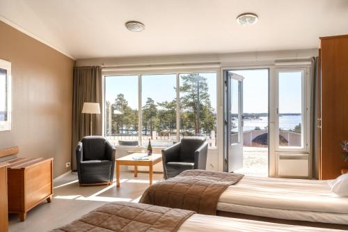 a hotel room with a bed and two chairs at Spa Hotel Kasnäs in Kasnäs
