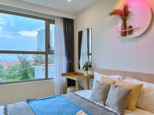 a bedroom with a bed and a large window at The Song Boutique Apartment in Vung Tau